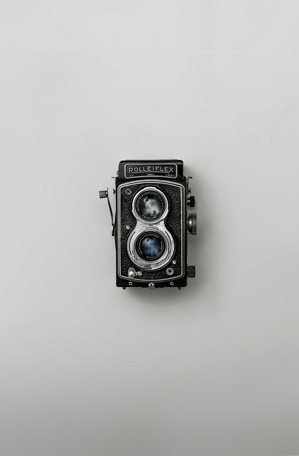 Vintage Rolleiflex twin-lens reflex camera on a light backdrop